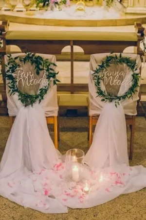 Dekoracja ślubna na krzesła z napisami 'Pan Młody' i 'Panna Młoda' wyciętymi laserem z białej plexi