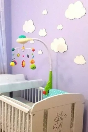 Dekoracyjne chmurki wycięte laserem z białej sklejki, zamocowane na ścianie w pokoju dziecięcym