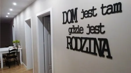 Dekoracyjny napis na ścianie w korytarzu: DOM jest tam gdzie jest RODZINA