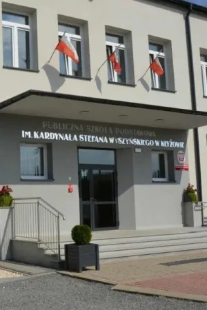 Lustrzany napis z nazwa szkoly podstawowej zamontowany nad wejsciem do budynku