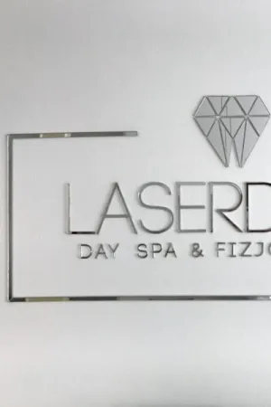 Logo LaserDay Day Spa & Fizjo wycięte laserem z lustrzanej plexi, zamocowane na białej ścianie