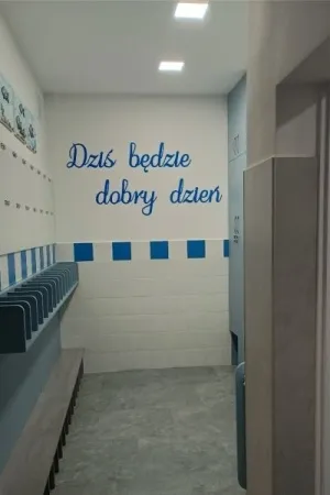 Motywujacy napis dzis bedzie dobry dzien na scianie szkolnej szatni