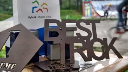 Drewniana nagroda z napisem BEST TRICK na stole podczas zawodów sportowych w Rybniku.