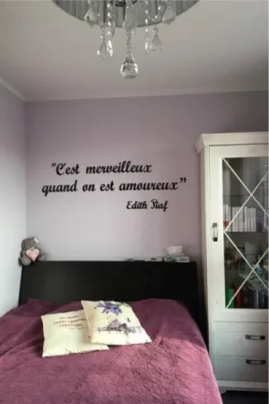 Napis C'est merveilleux quand on est amoureux wykonany ze sklejki, ozdoba ściany w sypialni