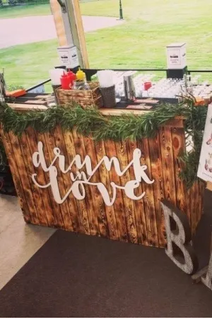 Dekoracyjny biały napis Drunk in Love na rustykalnym barze