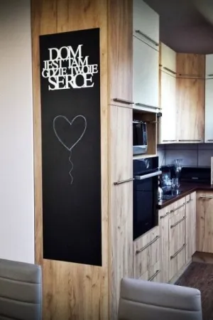 Napis Dom jest tam gdzie Twoje serce wykonany ze sklejki, umieszczony na tablicy w kuchni