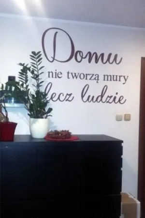 Napis Domu nie tworzą mury lecz ludzie wykonany ze sklejki, ozdoba ściany w salonie