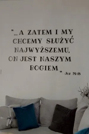 Napis: A zatem i my chcemy służyć Najwyższemu, On jest naszym Bogiem Joz 24:18, wycięty laserem z czarnej sklejki