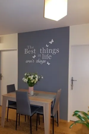 Dekoracyjny napis na ścianie w jadalni: The best things in life aren’t things