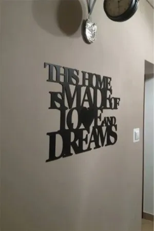 Napis This home is made of love and dreams wykonany ze sklejki, ozdoba ściany w przedpokoju
