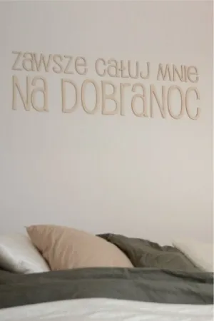 Napis dekoracyjny na ścianie: Zawsze całuj mnie na dobranoc w jasnej sypialni