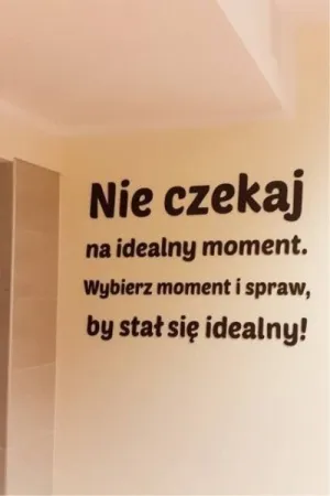Czarny napis wycięty laserem: 'Nie czekaj na idealny moment' na ścianie w jasnym wnętrzu