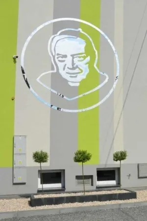 Portret patrona szkoly wykonany z lustra akrylowego na elewacji budynku