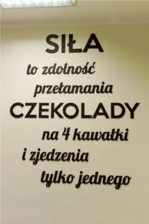 Napis: 'Siła to zdolność przetamania czekolady na 4 kawałki i zjedzenia tylko jednego' wycięty laserem z czarnej sklejki