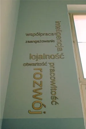 Drewniane napisy wartosci firmowe zamontowane na scianie biura