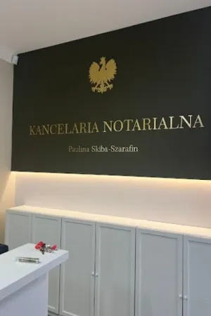 Złoty napis Kancelaria Notarialna na ciemnozielonej ścianie